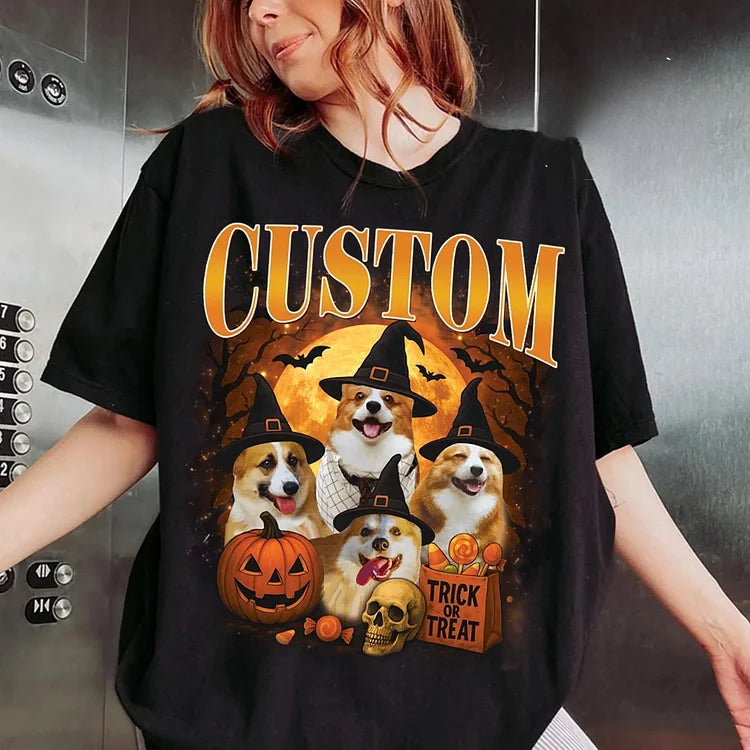 Person wearing a black t-shirt with Halloween-themed design featuring dogs in costumes and text.